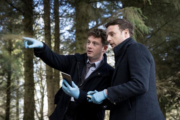 Bild 1 von 6: DI Archie Dent (Josh Bolt, l.) macht Harper (Andrew Gower, r.) mit den Lokalitäten des neuen Falls vertraut.