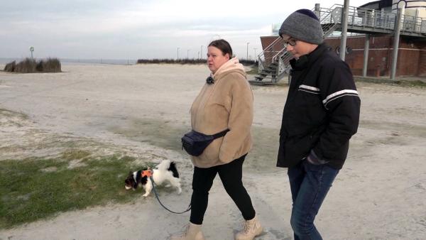 Bild 1 von 2: Sandra, Angelo und Hund Balou sind heute am Nordseestrand. Angelo hat schulfrei, weshalb ein Ausflug ans Meer möglich ist. Auch wenn es schön ist, haben sie nicht mit der kalten Brise gerechnet.