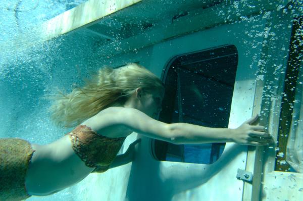 Bild 1 von 2: Emma (Claire Holt) versucht den eingeschlossenen Zane (Burgess Abernethy) aus dem untergegangenen Boot von Miss Chatham zu befreien.