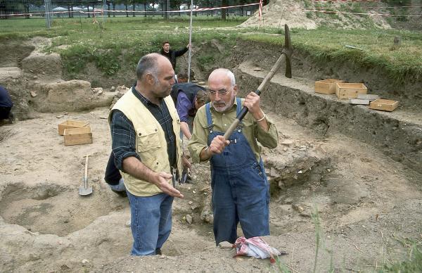 Bild 1 von 3: Peter (Peter Lustig, r.) packt an. Auf einer Ausgrabungsstätte schwingt er die Hacke, wird aber von einem der Experten (Ludger Burmann, l.) gestoppt. Peter erfährt von ihm mehr über alte Scherben und das Leben der Römer.