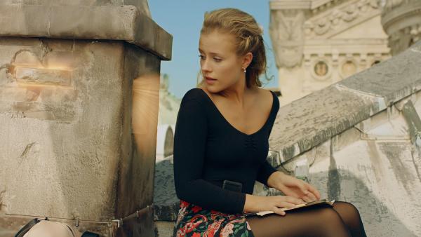 Bild 1 von 6: Lena (Jessica Lord) wartet am Schornstein auf dem Dach der Pariser Oper auf einen Brief von Henri, der im Jahr 1905 fest sitzt und nicht zu ihr kommen kann.