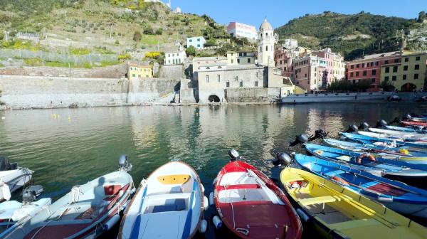Bild 1 von 5: Bunte Fischerboote schaukeln im Hafen von Vernazza - eingerahmt von pastellfarbenen Häusern, steilen Weinterrassen und der markanten Kirche Santa Margherita d?Antiochia.