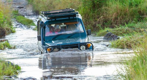 Bild 1 von 5: Während der Regenzeiten schwellen die kleinen Bäche oft in wenigen Stunden stark an, so dass manchmal tiefe Furten durchfahren werden müssen. Der Filmwagen ist zum Glück mit einem \