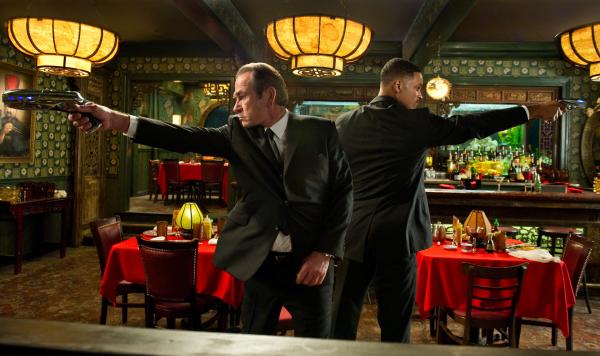 Bild 1 von 15: Agent K (Tommy Lee Jones, l.) und sein Partner Agent J (Will Smith, r.) sind zurück. Auf der Suche nach einem entflohenen Straftäter gelangen die beiden in einem China-Restaurant in einen Hinterhalt und müssen sich den Weg durch eine Horde außerirdischer Killer freischießen.