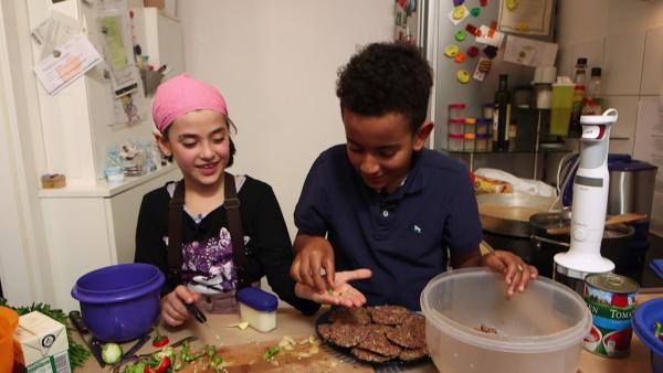 Bild 1 von 2: Zerrin und Amanuel schneiden Chillischoten