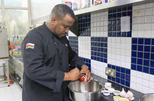 Bild 1 von 2: Küchenchef Nader Al Aisari bereitet Omans traditionelles Festgericht zu.