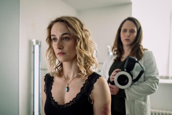 Bild 1 von 10: Annette Steiner (Pia Barucki, l.), eine gute Bekannte der toten Sophie Nöll, gibt an, kürzlich von ihrem Ex-Mann geschlagen worden zu sein. Mala Murphy (Emily Cox, r.) fotografiert die Hämatome.
