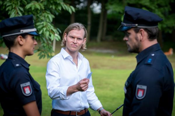 Bild 1 von 7: Stephan Niemeyer (Lennart Lemster, M.) behauptet, zur Tatzeit ein Alibi zu haben und verweist Pinar (Aybi Era, l.) und Kris (Marc Barthel, r.) bei weiteren Fragen an seinen Anwalt.