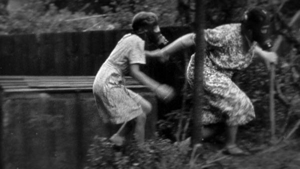 Bild 1 von 3: Frauen mit Gasmasken auf der Suche nach Schutz während eines deutschen Luftangriffs.