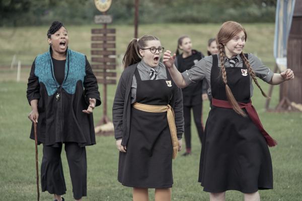 Bild 1 von 2: Das Rennen ist im vollen Gange. Frau Drill (Shauna Shim, l.) und die Freundinnen Maude (Megan Hughes, M.) und Mildred (Lydia Page, r.) feuern Edith an. Die Drei haben alles dafür getan, dass Edith einen guten Start hat und sich gegen Frau Hanfnessels Schülerin durchsetzen kann.
