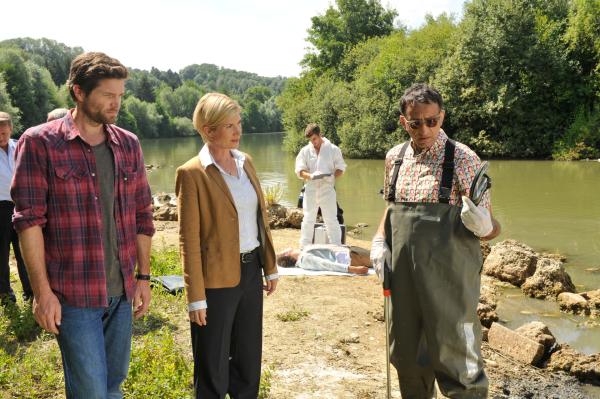 Bild 1 von 6: Während der Gerichtsmediziner Benedikt Förster (Florian Wu?nsche, M.) die Leiche von Constantin Jung (Jonas Matthes) untersucht, ist der KTUler Jan Arnaud (Mike Zaka Sommerfeldt, r.) im Uferbereich auf Spurensuche. Martina Seiffert (Astrid M. Fu?nderich) und Jo Stoll (Peter Ketnath) hoffen, dass er Beweismaterial sicherstellen kann.