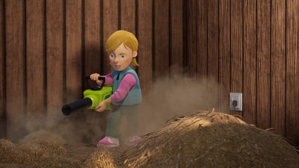 Bild 1 von 3: Statt das Heu zusammenzuharken, benutzt Sarah einen Laubbläser.