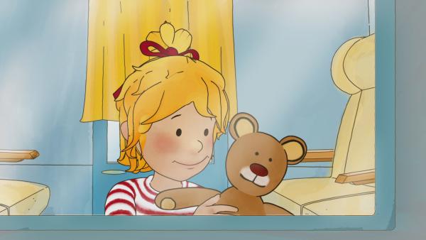 Bild 1 von 3: Conni fliegt über den Wolken. Mit Teddy im Arm beobachtet Conni, wie die Häuser unter ihr kleiner und kleiner werden.