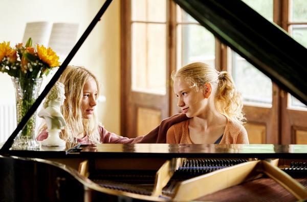 Bild 1 von 10: Lotte (Delphine Lohmann, rechts) spielt Luise (Mia Lohmann) auf dem Klavier vor.