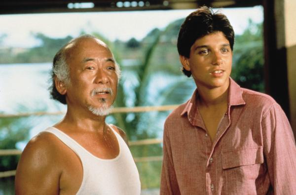 Bild 1 von 3: Daniel-san (Ralph Macchio, r.) begleitet Mister Miyagi (Pat Morita, l.) auf eine Reise zurück in seine Heimat Okinawa. Doch ein ungeklärter Konflikt aus seiner Vergangenheit sucht Mister Miyagi heim.