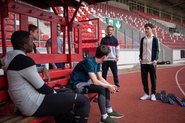 Bild 1 von 4: Die Sprintstaffel um Badu (Arnold Makuissie, 1.v.li.) Cäcilia (Carlotta Weide), Bela (Philip Müller) und Viktor (Fridolin Sommerfeld, v.l.n.r.) trainiert dieses Jahr hart, das muss auch Anton (Lasse Timmel, 1.v.re.) neben seinem Vater Sportkoordinator Hauser (Frederic Heidorn, 2.v.re.) feststellen.