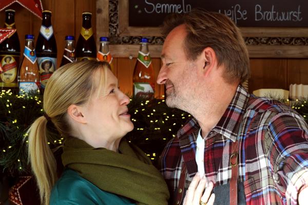 Bild 1 von 4: Vera (Sybille Waury) und Gregor (Holger Matthias Wilhelm) verbringen beim gemeinsamen Einsatz am Christkindlsmarktstand mehr Zeit miteinander.