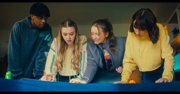 Bild 1 von 4: In der Wohnung von Alices Mutter betrachten Finn (Jordan Adene), Maeve (Skye McClenaghan), Bea (Aoife Hughes) und Alice (Scarlett Rayner, v.l.n.r.) die Ausdrucke der Fotos, die sie von der aufgemalten Wegbeschreibung auf Maeves Arm gemacht haben. Bea weiß, wo sie die Suche nach ihren Freunden starten müssen.