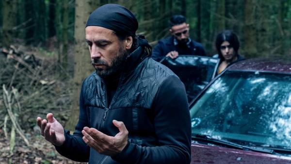 Bild 1 von 5: Yusuf (Ola Rapace, l.), der Anführer der Entführer, betet zu seinem Gott. Im Hintergrund wird June (Yasmin Mahmoud, r.) ins Auto geschoben.