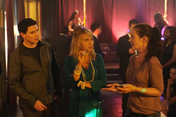 Bild 1 von 4: Selma Kirsch (Yve Burbach, r.) befragt zusammen mit Rico Sander (Benjamin Strecker, l.) die Nachtclub-Besitzerin Helga Fischer (Anica Dobra, M.). Die Ermittler ziehen dabei die Aufmerksamkeit der Club-Besucher (Komparsen) und Stripperinnen (Komparsinnen) auf sich.