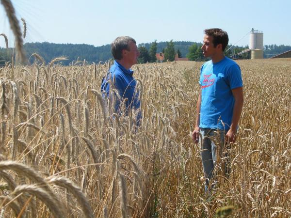 Bild 1 von 3: Willi (rechts) lässt sich von Biobauer Hans den Weizenanbau erklären.