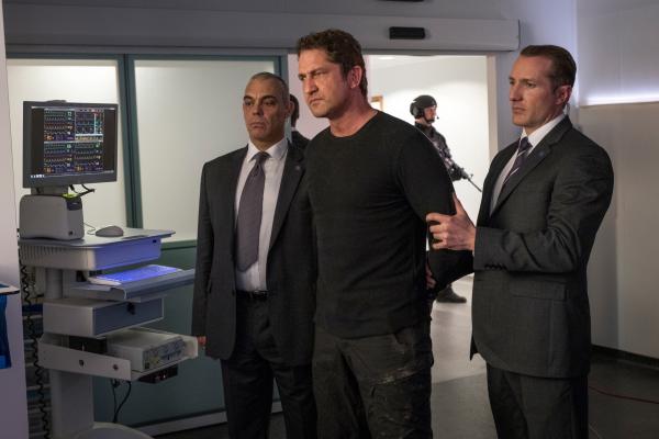 Bild 1 von 15: Um den Präsidenten von seiner Unschuld zu überzeugen, geht Mike Banning (Gerard Butler) ein hohes Risiko ein und lässt sich von zwei Sicherheitsmännern (Darsteller unbekannt) festnehmen.