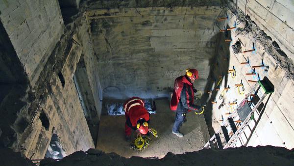 Bild 1 von 3: Zwei Sprengmeister platzieren den Sprengstoff im Mauerwerk, um das betreffende Gebäude kontrolliert zum Zusammenbruch zu bringen.