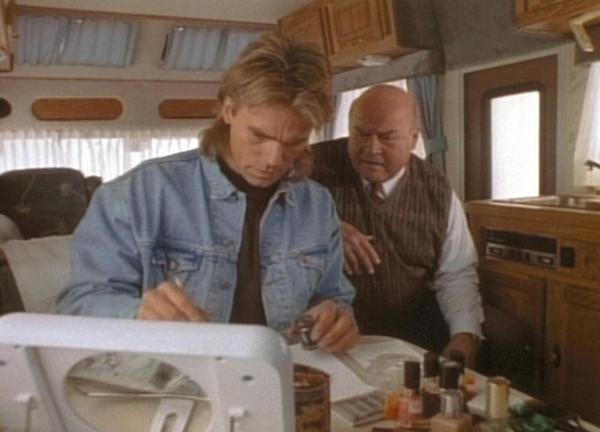 Bild 1 von 4: MacGyver (Richard Dean Anderson, l.) und Thornton (Dana Elcar, r.) stellen an Hand der Fingerabdrücke fest, dass Roxanne und Carla ein und dieselbe Person sind.