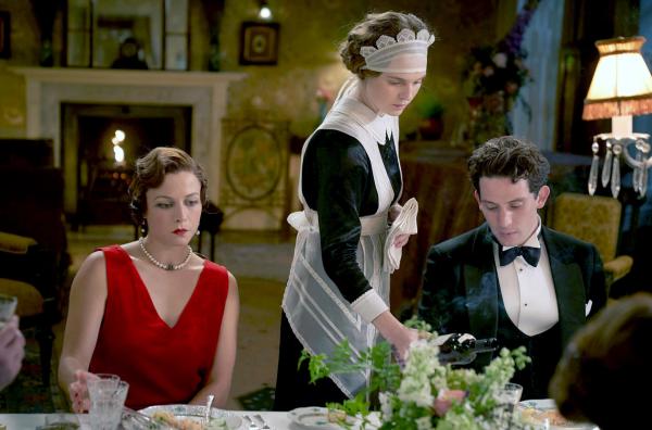 Bild 1 von 8: Bei einem Bankett bedient Hausmädchen Jane Fairchild (Odessa Young, Mi.) Paul Sheringham (Josh O'Connor, re.) und seine Verlobte Emma Hobday (Emma D'Arcy, li.).