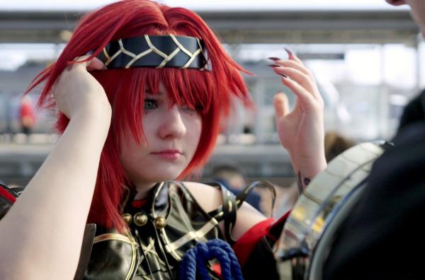 Bild 1 von 3: Sophy verwandelt sich am Bahnhof in eine Heldin aus dem Spiel ?Wuthering Waves? ? auf dem Weg zur Leipziger Buchmesse, die auch zum Magneten für Cosplayer geworden ist.