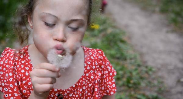 Bild 1 von 4: Emma-Lou pustet eine Pusteblume.