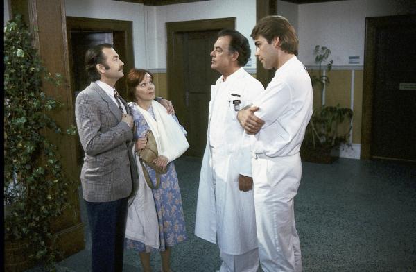 Bild 1 von 2: Konrad Pesch (Jürgen Schmidt) bringt Gertrud Melldorf (Loni von Friedl) ins Krankenhaus zurück und versucht gegenüber Klaus (Klausjürgen Wussow) und Udo Brinkmann (Sascha Hehn) die Verletzung als ein Unfall hinzustellen.