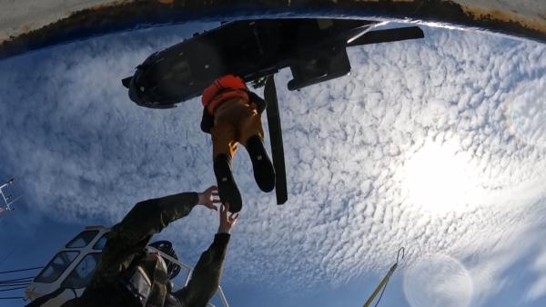 Bild 1 von 1: Rettungsübung über der Nordsee: Ein Besatzungsmitglied wird per Winde aufgenommen - Präzision und Vertrauen sind entscheidend.