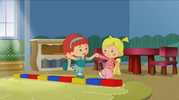 Bild 1 von 5: Tanja übt mit Zoés Hilfe über Bauklötzer zu balancieren.