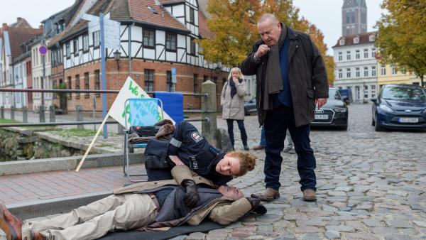 Bild 1 von 5: Nachdem die Straße von der Demonstration geräumt wurde, findet Paula Moorkamp (Stella Hinrichs, l.) das Vereinsmitglied Professor Julius Eberfeld (Uwe Stranz, M.) leblos auf. Während Paula Moorkamp nach einem Lebenszeichen sucht, funkt Kriminalhauptkommissar Jan Reuter (Udo Kroschwald, r.) nach Verstärkung. Doch ist der Professor noch zu retten? Was ist mit ihm passiert?