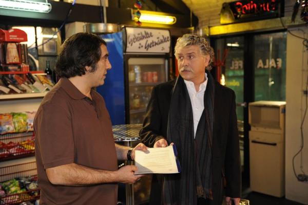Bild 1 von 13: Süleyman (Hussi Kutlucan, l.) ist überglücklich, als er ein Mann vom Gesundheitsamt (Mario Schüning, r.) ihm die Papiere bringt, damit er seinen Imbiss wieder eröffnen kann ...