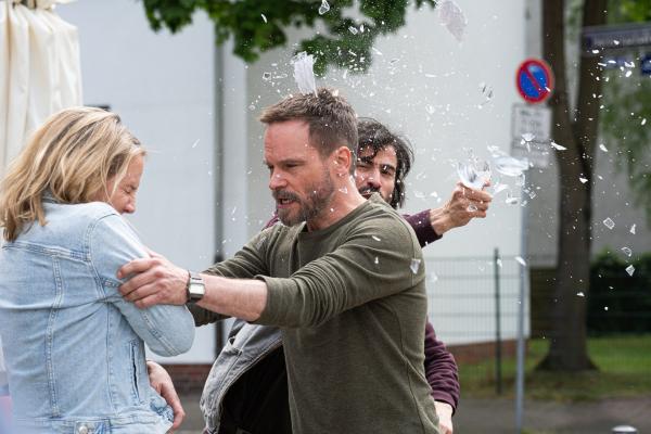Bild 1 von 14: Rosa Schmelke (Katrin Wichmann) gerät in eine eskalierende Situation, als Leo Oswald (Wanja Mues, Mi.) eingreift und sie schützt. Hinter ihnen attackiert David Rudolf (Samy Challah, r.) die Szene - ein Moment, der die angespannte Dynamik des Falls offenlegt.