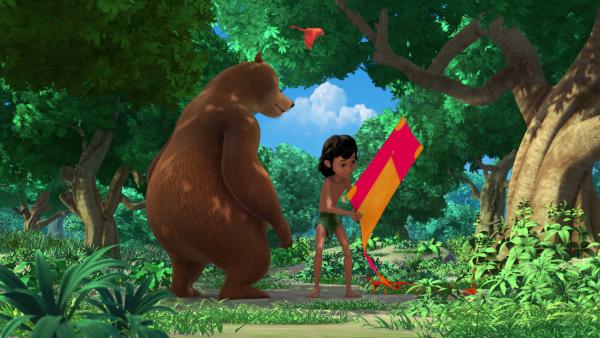 Bild 1 von 5: Mogli (r.) hat einen Drachen gefunden. Zusammen mit dem kleinen Vogel Darsi will er mit dem neuen bunten Fluggerät spielen gehen.