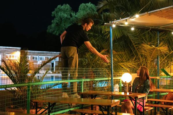 Bild 1 von 3: Ben (Harry Lawtey) fordert Emma (Jessica Barden) auf, heimlich über den Zaun ins Freibad zu klettern.