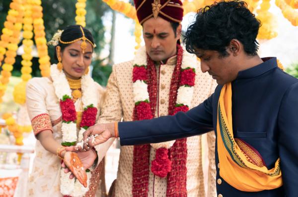 Bild 1 von 4: Die Hochzeit von Renuka (Monica Kumar, li.) und Kiran (Nicholas Brown, Mi.) wird für Nik (Rudi Dharmalingam, re.) zur Zerreißprobe.