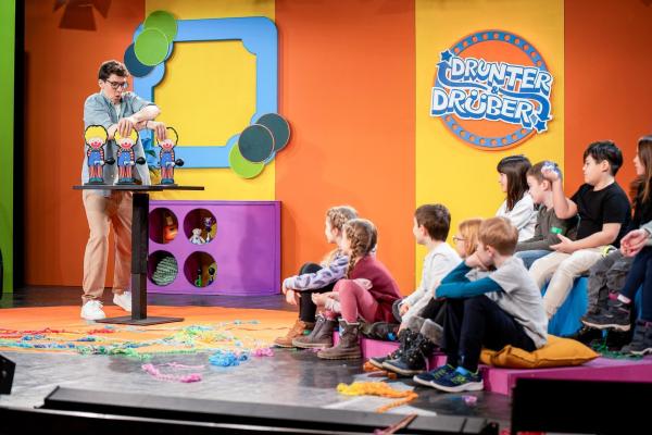 Bild 1 von 8: Im Bild: Christoph Hirschler zeigt dem Kinderpublikum einen Zaubertrick mit drei Clown-Figuren auf der Bühne.