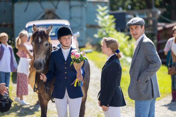 Bild 1 von 5: Zunächst wirkt Heddesta wie die Erfüllung von Mollys (Saga Samuelsson, l.) Träumen. Der Reitlehrer Tommy (Jonas Karlsson, r.) unterstützt sie bei ihrer Reitkarriere. Doch irgendwann offenbart er sein wahres Ich. Auch Sandra (Amanda Pajus, M.) leidet unter Tommy.