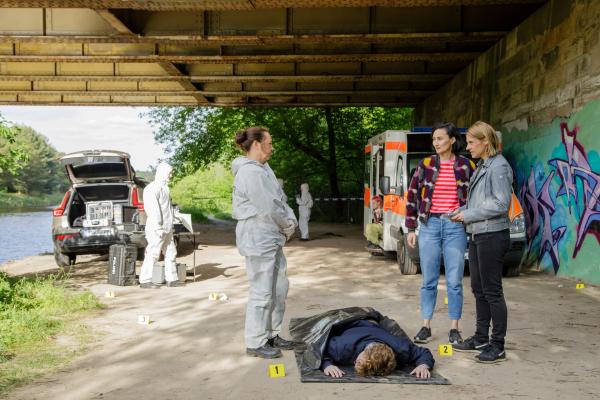 Bild 1 von 4: Unter einer Brücke wird der junge Charlie Lindner gefunden. Jutta Specht (Gabriele Vo?lsch, 2.v.l.) bespricht am Tatort erste Mutmaßungen mit Pauline Hobrecht (Agnes Decker, 2.v.r.) und Tamara Meurer (Anja Pahl, r.). (Komparsen im Bild)
