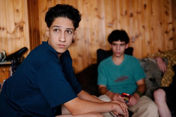 Bild 1 von 1: Pit (Metkan Kalan, links) liest im Klassenchat, dass über ihn gelästert wird. Seine Freunde drängen ihn sich zu wehren.