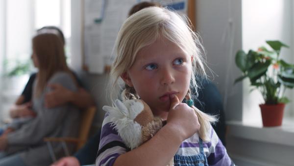 Bild 1 von 5: Vilda (Sofia Sittnikow) ist ängstlich in der Zahnarztpraxis und versteckt sich hinter ihrem Stofftiger.