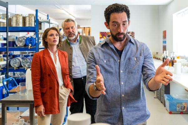 Bild 1 von 2: Im Bild: Simon Haflinger (Adrian Moskowicz, r.), ein Mitarbeiter des Duftlabors des Opfers, gibt den Kommissaren Stadler (Dieter Fischer, M.) und Andresen (Sophie Melbinger, l.) zu verstehen, dass seine Expertise wesentlich zum Erfolg der Firma beitrug.