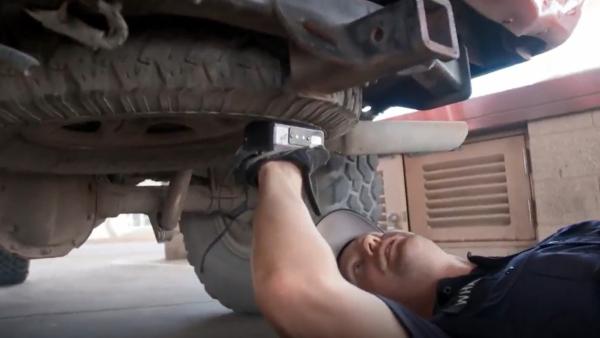 Bild 1 von 2: Mit einem Dichtemessgerät überprüft ein Beamter den Unterboden eines Trucks - ein ungewöhnlich hoher Wert könnte auf ein verstecktes Objekt hindeuten.