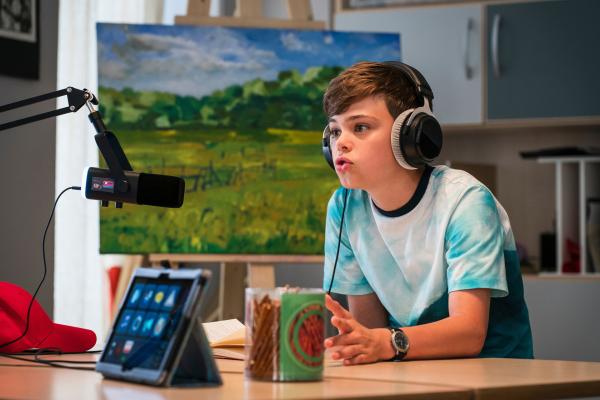 Bild 1 von 5: Hugo (Lennox Dreer) ist zu Gast in Massudas Podcast.
