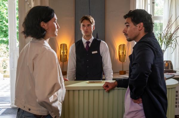 Bild 1 von 4: Pauline Hobrecht (Agnes Decker) und Samir Amari (Skandar Amini, r.) sind im Hotel und befragen den Auszubildenden Emil Trosdorf (Arne-Carlos Böttcher, M.). Er gibt ihnen den Hinweis, dass der Tote zusammen mit einer unbekannten Frau auf dem Zimmer war.