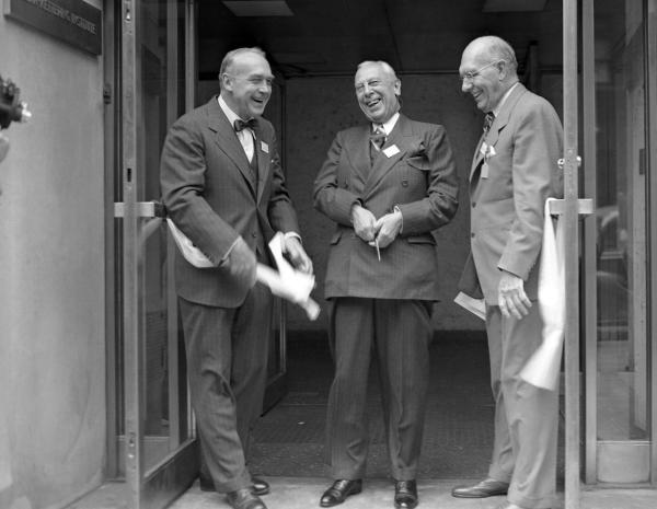 Bild 1 von 4: Im Bild: Lächeln ist angebracht, als Alfred P. Sloan, Jr. (Mitte), der den Großteil der Mittel zur Verfügung gestellt hat, das Band durchschneidet, um das neue 14-stöckige Sloan-Kettering-Institut für Krebsforschung zu eröffnen, das größte Labor seiner Art auf der Welt. Ihm zur Seite stehen bei der Zeremonie Reginald G. Coombe (links), Präsident des Memorial Hospital, zu dem das neue 3.175.000 Dollar teure Gebäude gehört, und Charles F. Kettering, Mitglied des Kuratoriums. Sloan, Vorstandsvorsitzender von General Motors, ist auch Mitglied des Kuratoriums des Instituts.